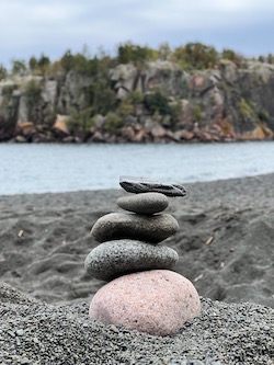 A pgoto of stacked rocks at a black sand beach